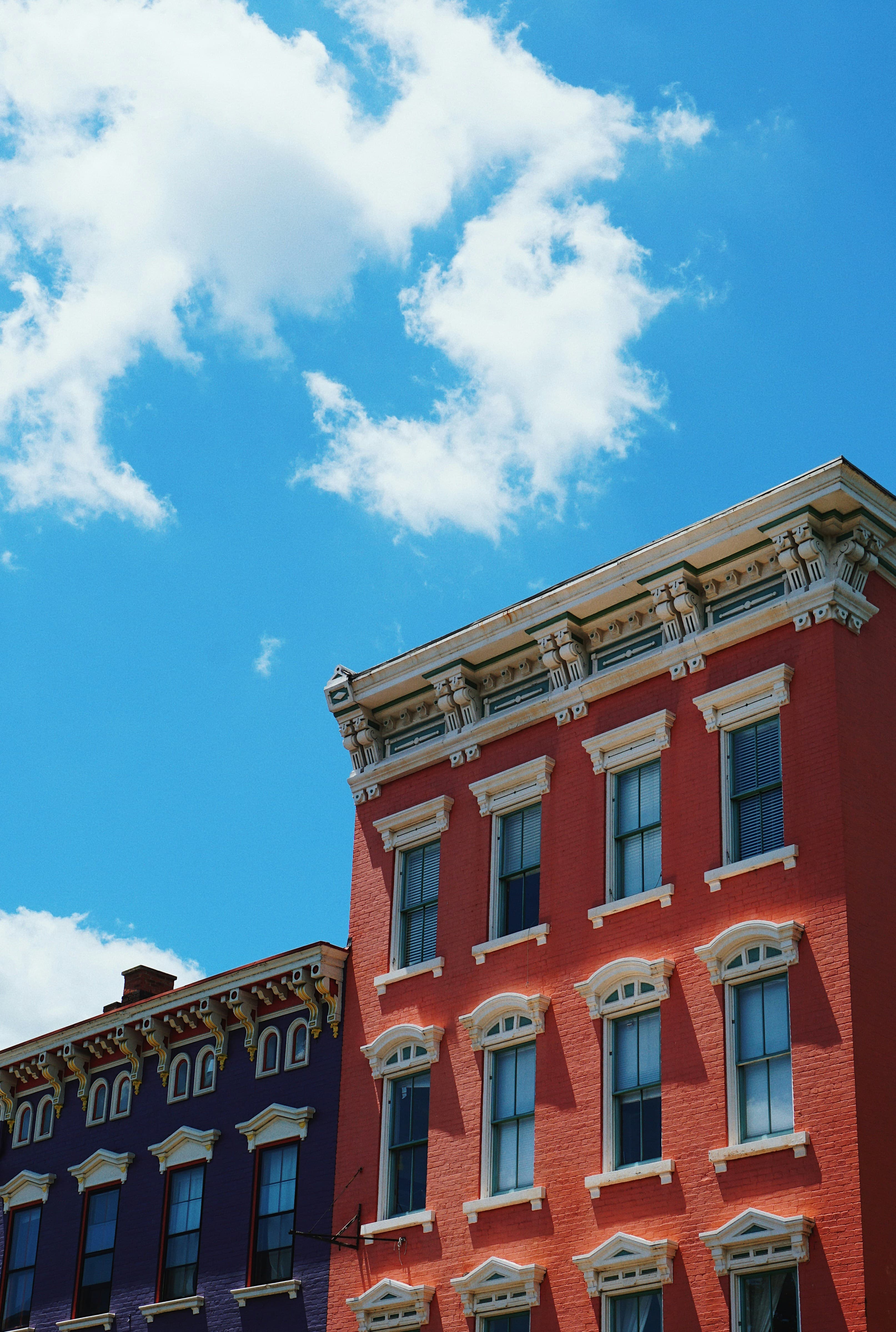 Row of colorful historic multi-family buildings against a blue sky